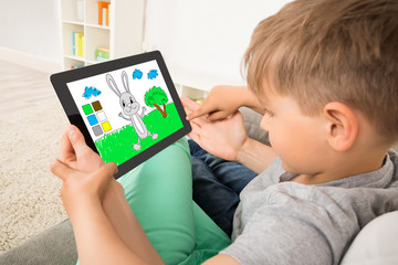 Boy Playing Game On Digital Tablet