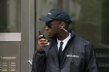 Security Guard Talking On Walkie-Talkie