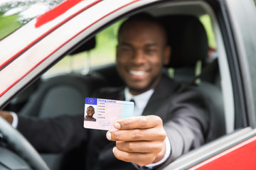 Businessman Showing His Driving License From Open Car Window