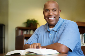 Middle age student working in library.