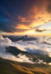 High mountain ridge in the clouds during sunrise. Beautiful panoramic landscape