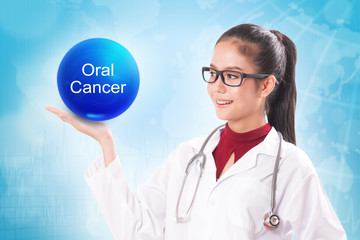 Female doctor holding blue crystal ball with oral cancer sign on medical background.