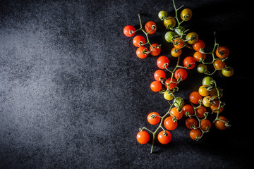 Fototapeta na wymiar Fresh cherry tomatoes on black wooden background