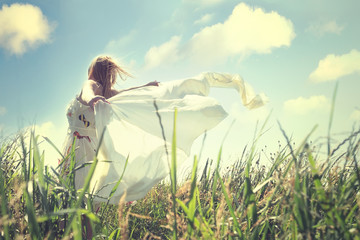 happy woman turning  around itself in a field