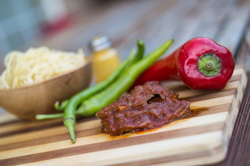 Beef with tomato sauce, sphagetti and vegetables.