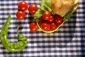Cooking lunch. Sandwiches and fresh vegetables are in the box for lunch, the remains of vegetables on the table.