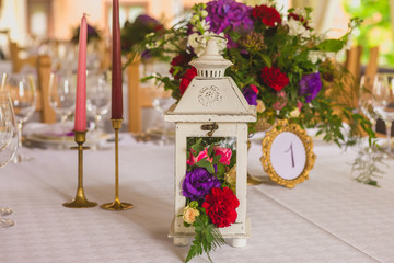 lantern decorated by flowers is on the table