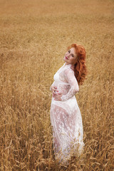 A woman with red hair in a wheat field.
