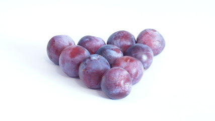 Obraz premium Спелые сочная сливы лежит на белом фоне