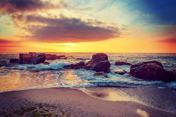 Sea coast after sunrise with rocks, blue water and sunny sky, natural seasonal summer hipster background