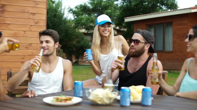 Group of young beautiful happy people having drinks at the picnic area