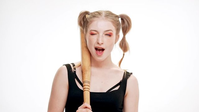 Young beautiful girl smiling, winking, kissing bat over white background. Slow motion.