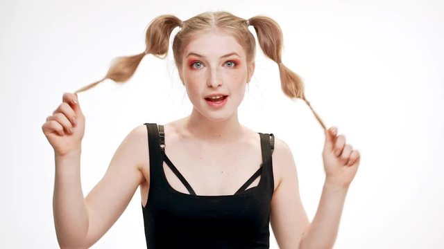 Young beautiful girl smiling, dancing over white background. Slow motion.