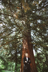 Bridegroom standing under tree