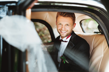 Bridegroom sitting in wedding car