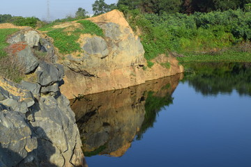 rocky lake with stone and plant reflect on the water