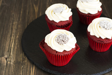 Red velvet cupcakes over wooden background