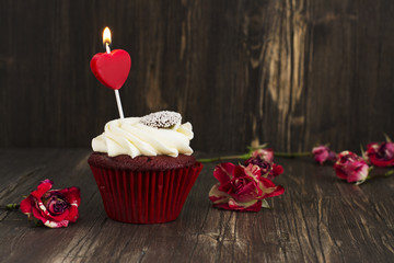 Delicious red velvet cupcake with burning candle