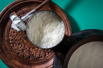 Fototapeta Indian sweet Lassi made up of milk, curd, sugar and salt mixed with ice cubes, served in a jumbo steel glass, prepared in traditional earthen pot obraz