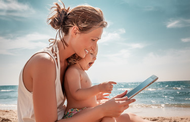 Mutter und Kind am Strand mit Computer