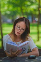 Obraz premium Girl with book reading at the park