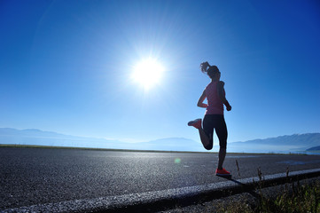  young fitness woman runner running on sunrise seaside trail