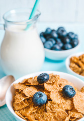healthy breakfast, cornflakes blueberry and milk, nuts, almond with text space top view close-up instagram filter