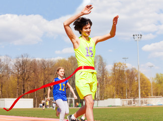 Happy teenage winner crossing the finish line