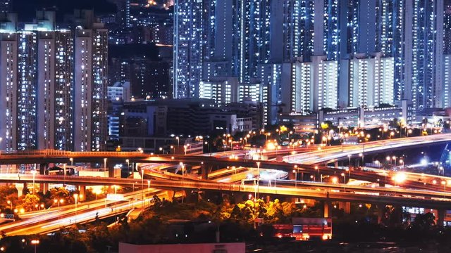 Car lights move fast on elevated highway road. Hong Kong high buildings at night