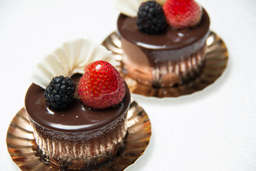  delicious small chocolate cake with some fruits on top