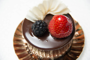 delicious small chocolate cake with some fruits on top