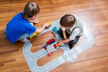 Two little boys plays with toy car