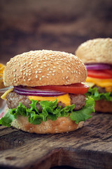 Cheeseburgers on wooden table with copy space
