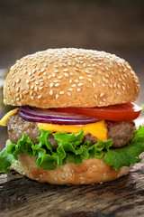 Cheeseburger on wooden table with copy space