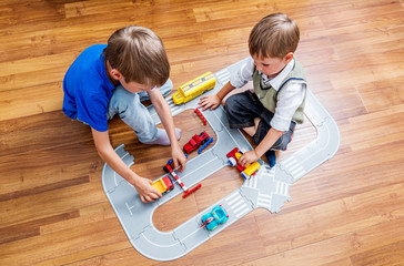 Two little boys plays with toy car