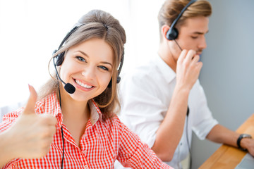 Young operator of call center showing thumb up