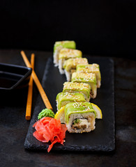 Traditional Japanese food - sushi, rolls and sauce on a black background.