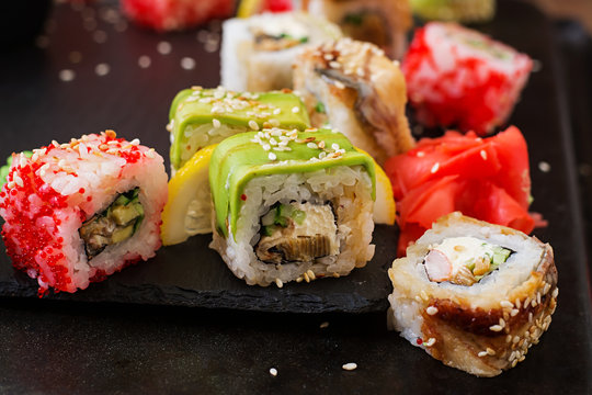 Traditional Japanese food - sushi, rolls and sauce on a black background.