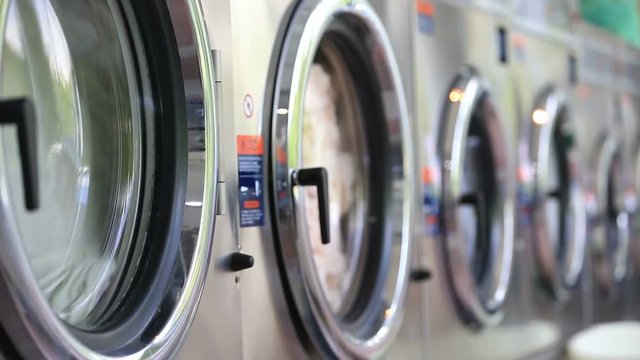 Washing machines at laundry washes colored clothing, and sheets