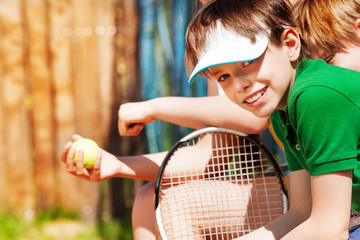 Fototapeta na wymiar Smiling sportive boy waiting for the tennis match