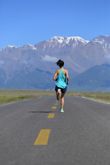 Obraz premium healthy lifestyle young fitness woman runner running on road