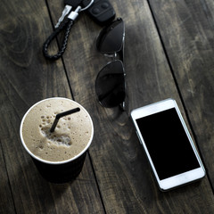 Cup of  coffee drink with sunglasses and mobile phone