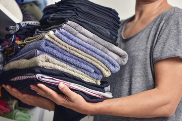 young man with a pile of folded clothes