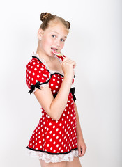 Portrait of happy beautiful young girl with sweet candys. pretty young woman dressed in a red dress with white polka dots holding two colorful lollipop