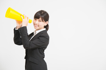 メガホンで応援をするスーツの女性