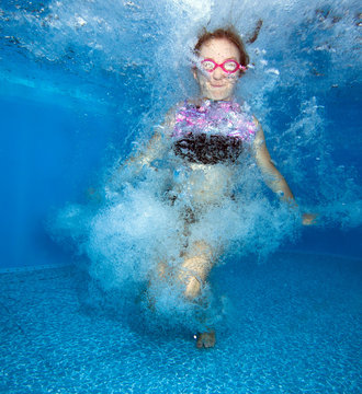 Young girl jumps and having fun in water. 