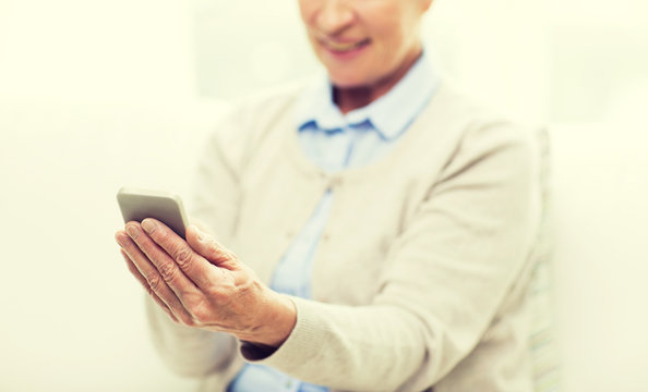 close up of senior woman with smartphone texting