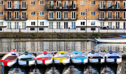 Row of boats decorated with different colours, moored in Millwall Outer Dock in London