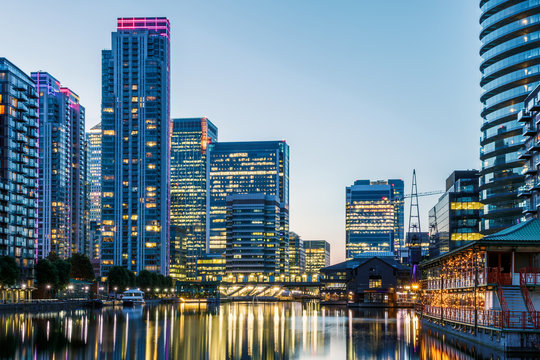Illuminated buildings in Canary Wharf, London seen from Millwall Dock