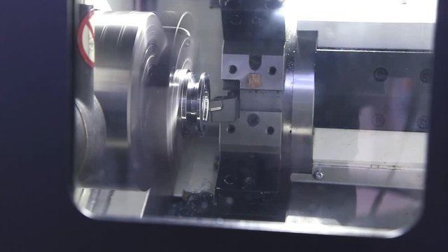 CNC milling machine makes some steel part on factory